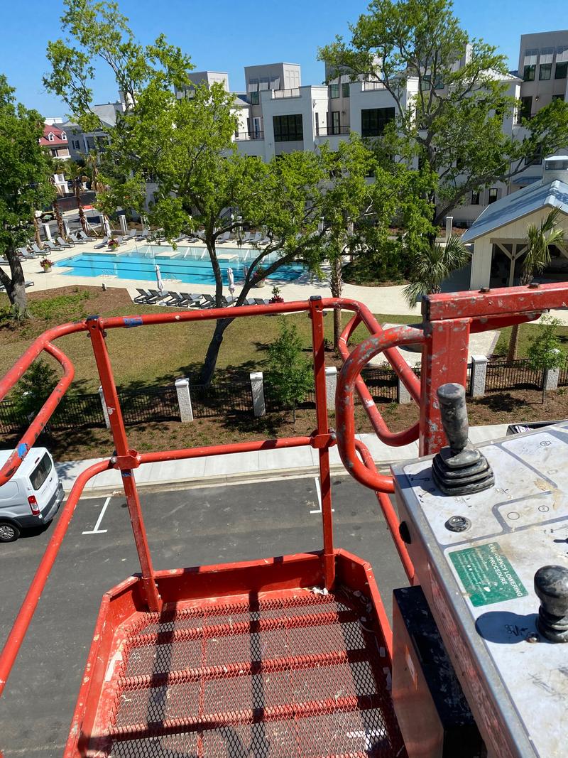 View from a lift platform toward a courtyard and multi-story building.