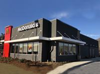 Restaurant exterior with dark cladding and large windows.