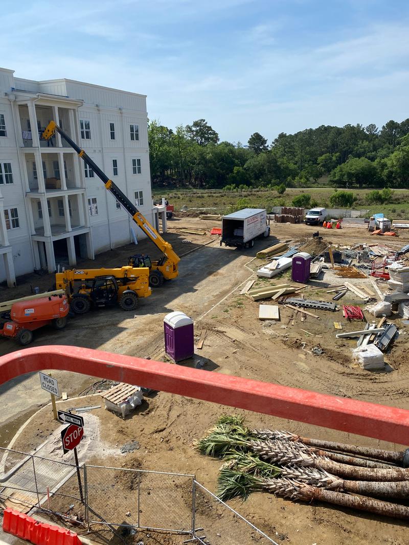 Multi-story building, access equipment and materials at a construction site.