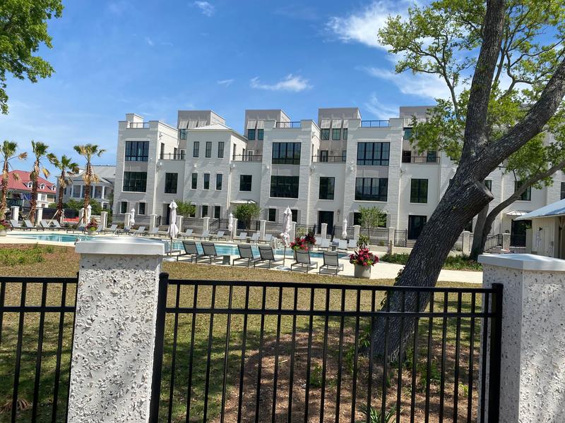 Courtyard, pool and multi-story building viewed through a fence.